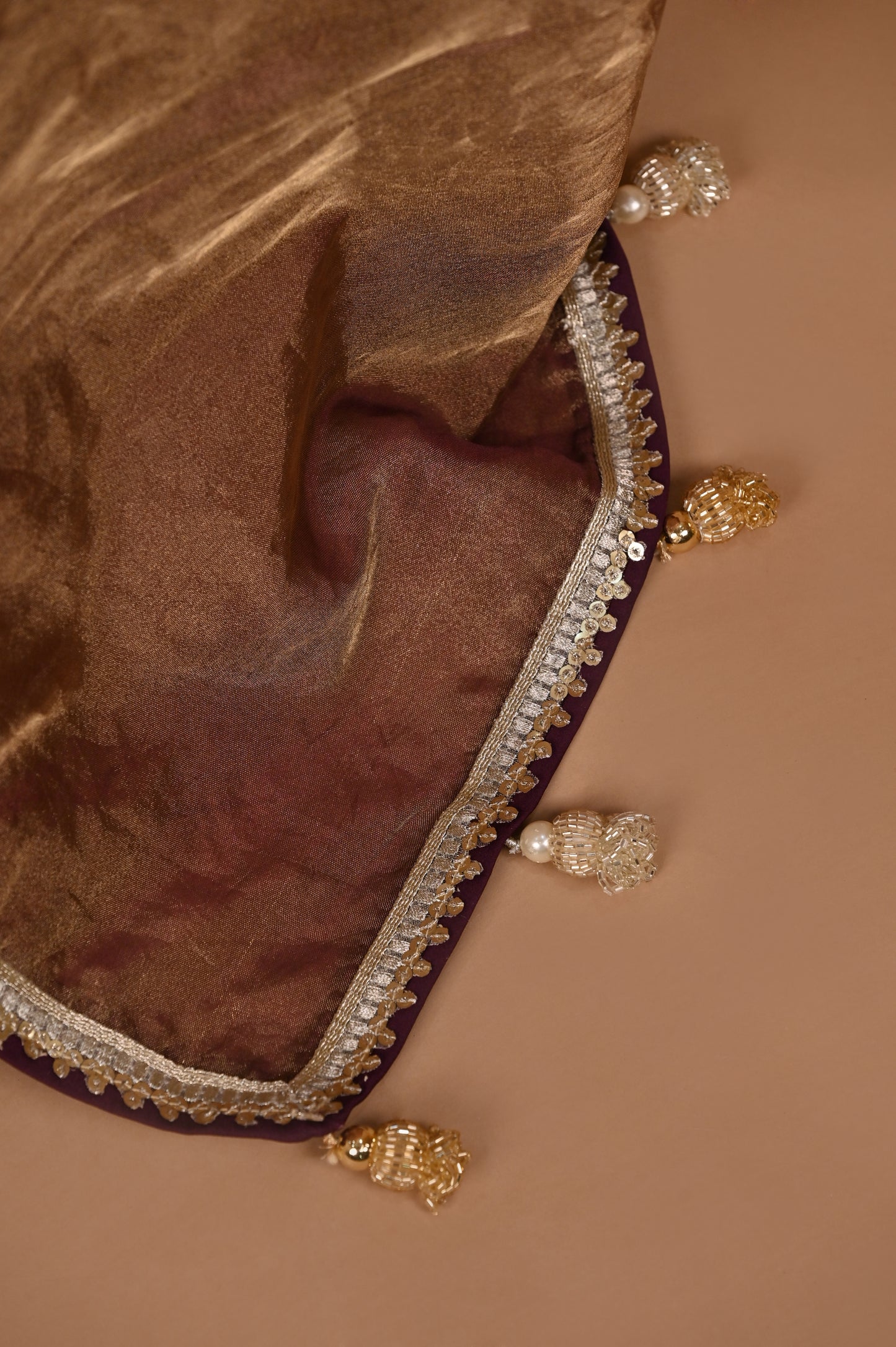 Luxurious Gold and Wine Tissue Saree with Elegant Tassel Details