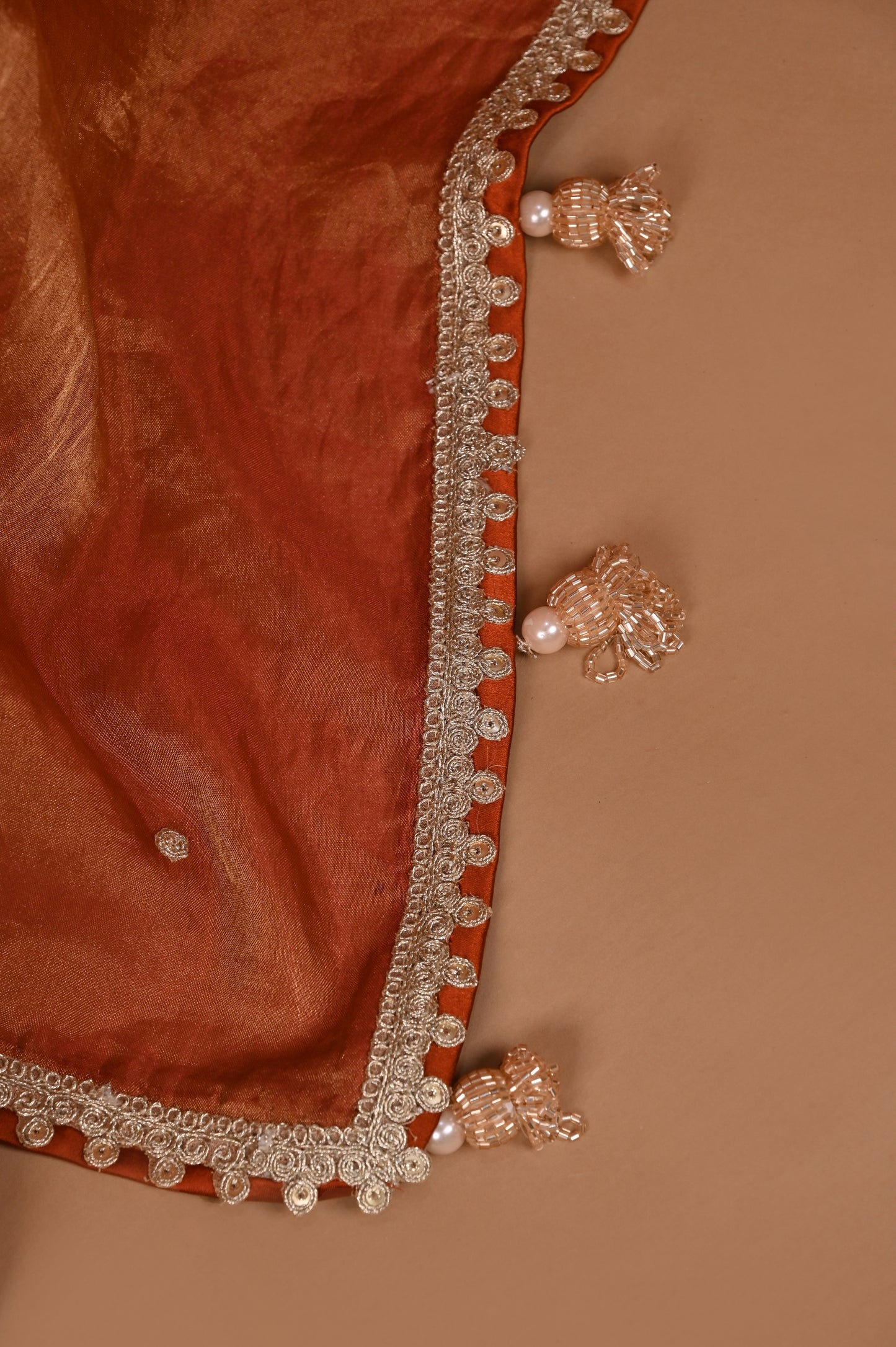 Earthy Rust Tissue Saree with Lace Border and Tassel Details