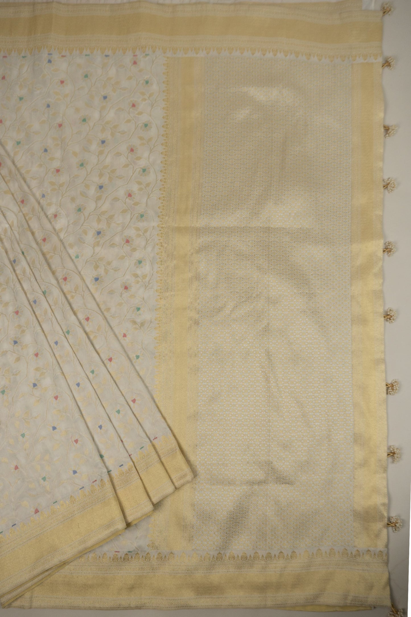White Banarasi Silk Saree with Pastel Shades, Gold Tissue Facing, Intricate Floral Jaal Weave, and Pearl & Gold Tassels on Saree and Blouse