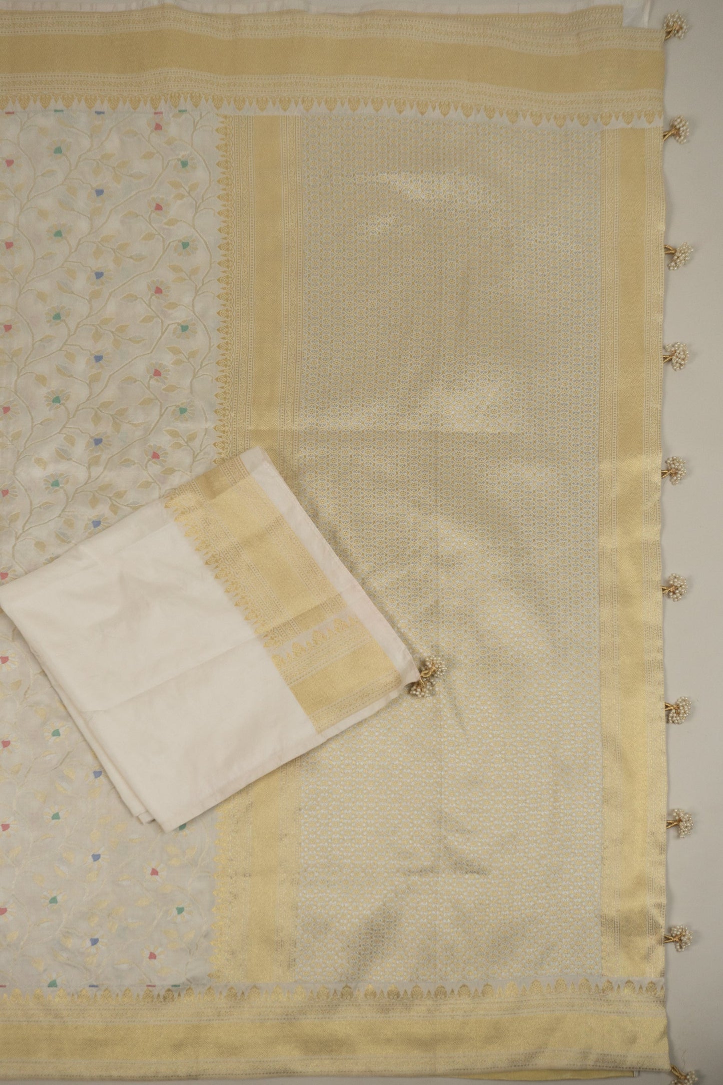White Banarasi Silk Saree with Pastel Shades, Gold Tissue Facing, Intricate Floral Jaal Weave, and Pearl & Gold Tassels on Saree and Blouse