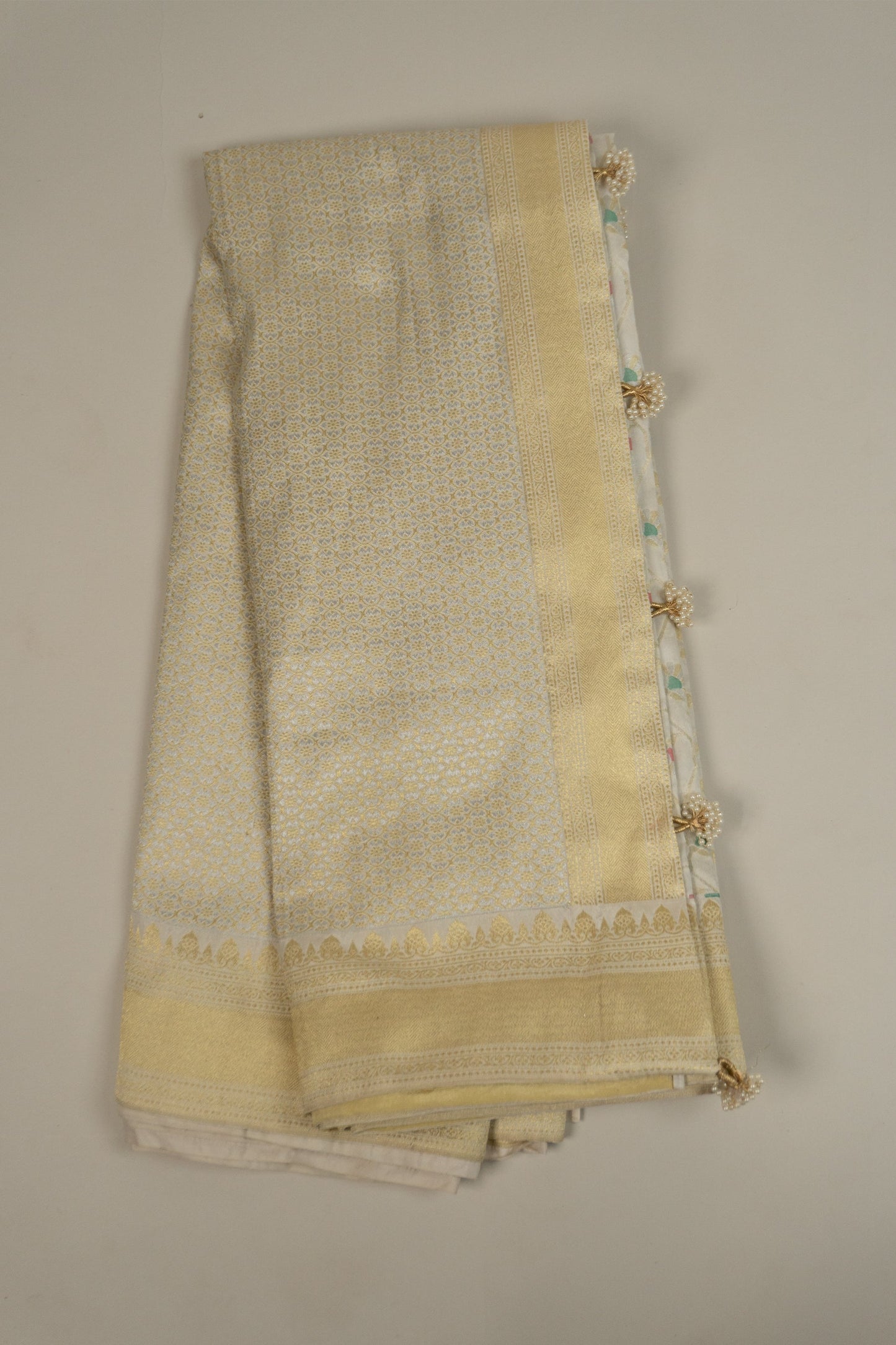 White Banarasi Silk Saree with Pastel Shades, Gold Tissue Facing, Intricate Floral Jaal Weave, and Pearl & Gold Tassels on Saree and Blouse