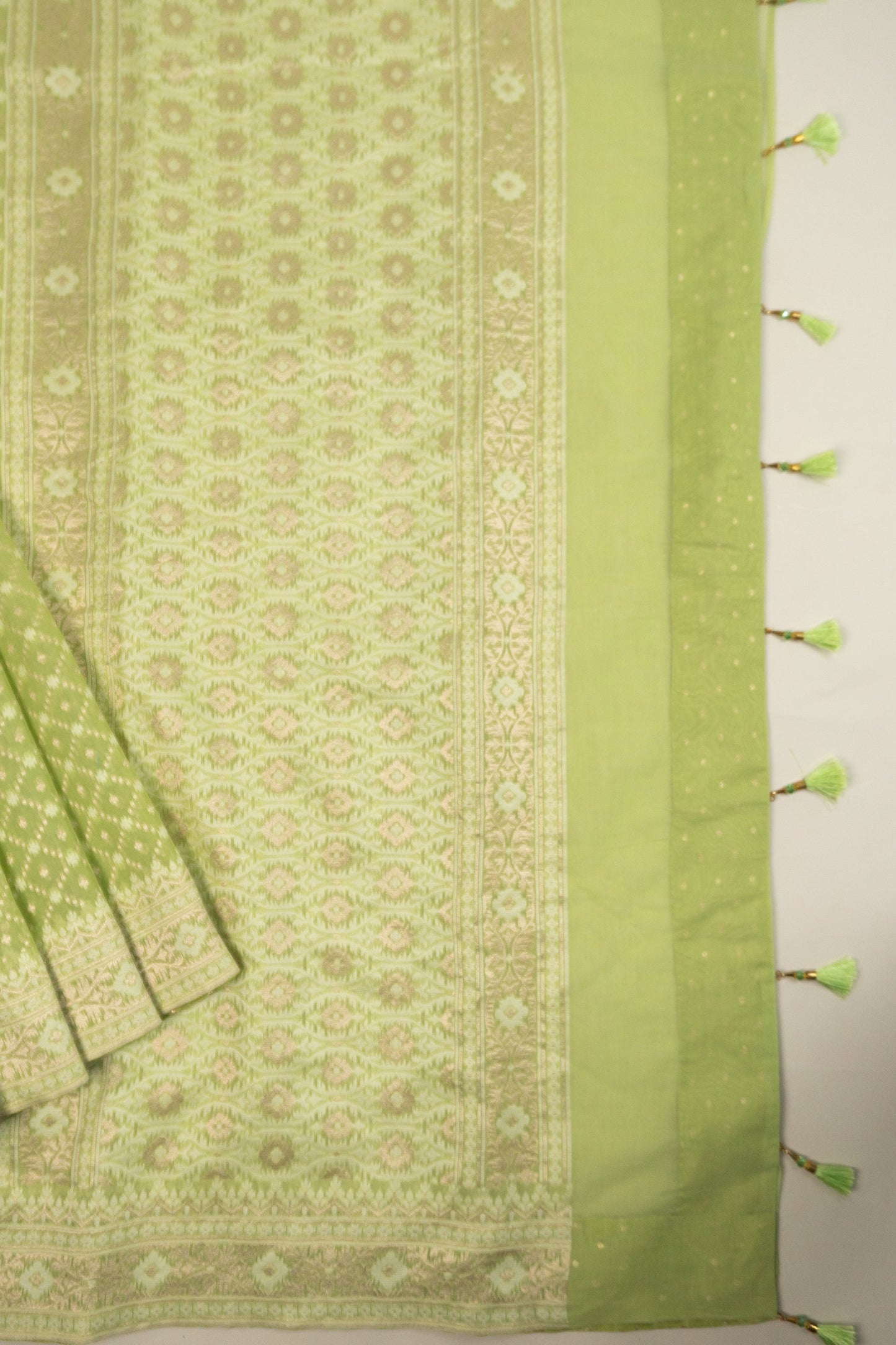 Pista Green Woven Organza Silk Saree with Intricate Diamond Pattern, Floral Border, Lurex Butta Facing, and Tassels on Saree and Blouse