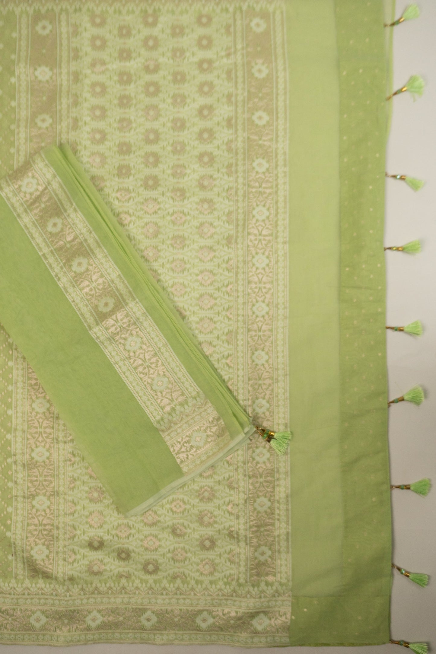 Pista Green Woven Organza Silk Saree with Intricate Diamond Pattern, Floral Border, Lurex Butta Facing, and Tassels on Saree and Blouse